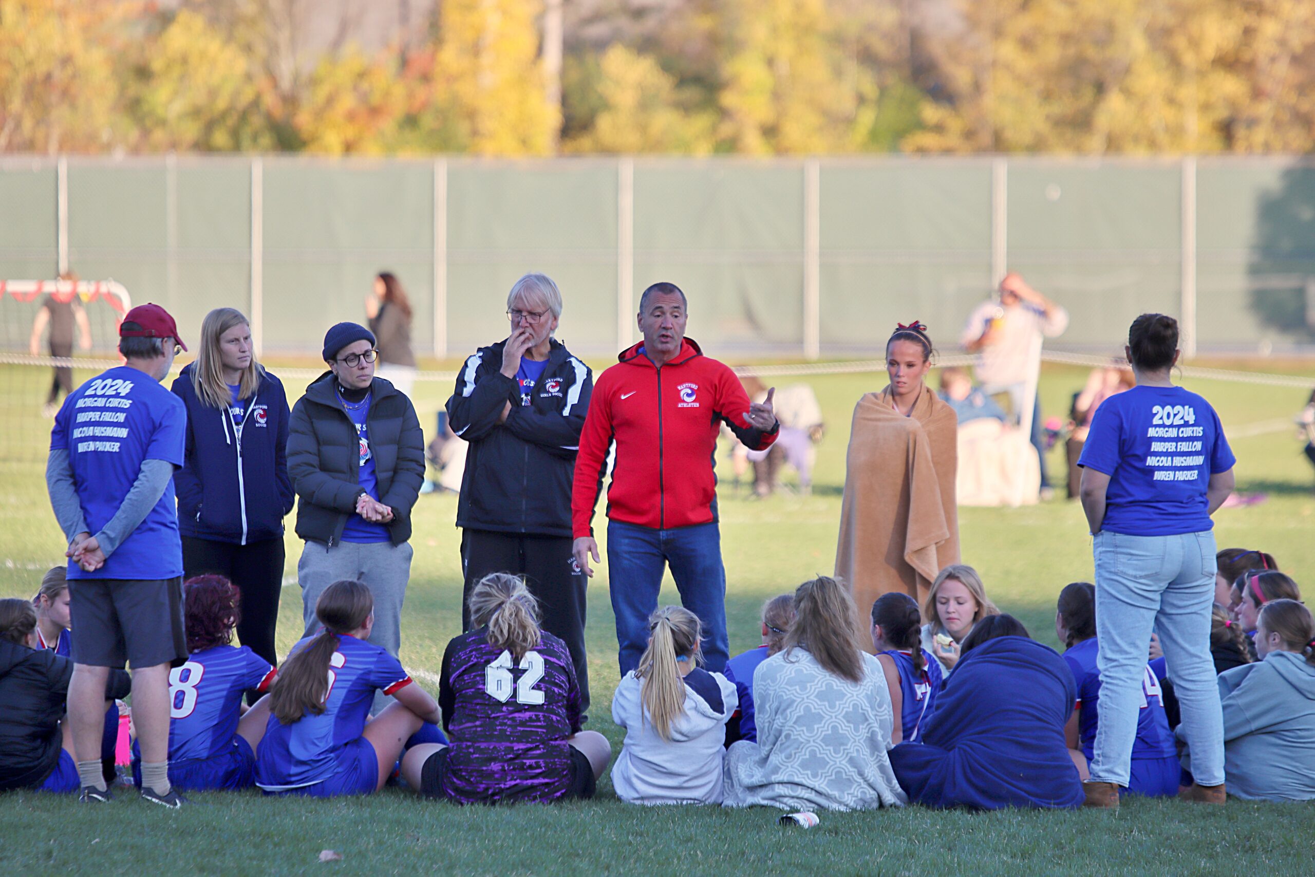 Team mates sitting down listening to coach